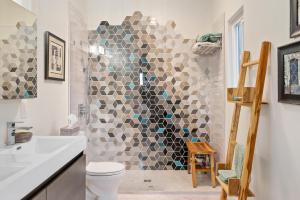 a bathroom with a shower with a toilet and a sink at Vista Mellow Cottage in San Miguel +30 photos