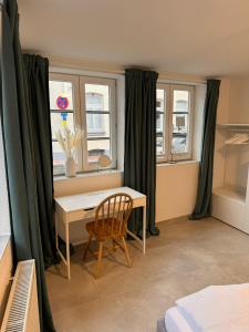 a room with a desk and a chair and windows at Buxtehude Altstadt Wohnung 82qm! 5 Schlafplätze! in Buxtehude