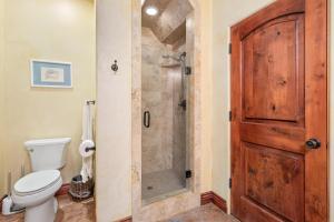 a bathroom with a shower and a toilet and a door at Vita Amorosa in Atascadero +17 photos