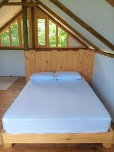 a large bed in a room with windows at Cabañita en el Bosque Seco Tropical -Microrreserva El Guamacho in Santa Marta