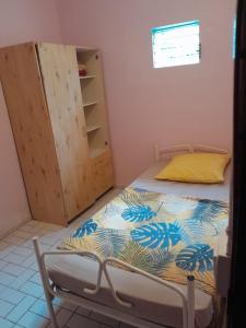 a small bedroom with a bed and a cabinet at Joli bas-de-villa in Les Abymes