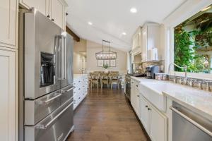 a large kitchen with white cabinets and stainless steel appliances at Vaquero Verano in Templeton