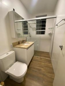 a white bathroom with a toilet and a sink at 24 Melhor custo benefício Aeroporto e Consulado in Porto Alegre +14 photos