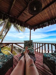 a person laying on a deck looking out at the ocean at Paraíso de Tabuba - casa de aluguel por temporada - 32km de Maceió-AL - Pé na areia - 24h de Frente para o mar in Barra de Santo Antônio