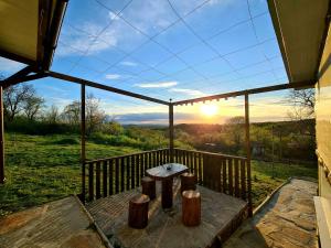 a screened in porch with a table and the sunset at Vila Zornica in Kondolovo