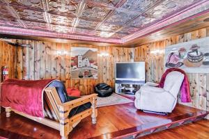 a room with a bed and two chairs and a television at Las Palmas in Templeton