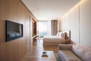 a hotel room with a couch and a bed and a television at Akelarre - Relais & Châteaux in Donostia-San Sebastián