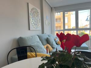 a living room with a couch and a table with a plant at Apartamento Verdemar in Suances