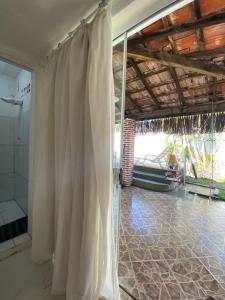 a bathroom with a shower and a shower curtain at Hostel Itaparica in Itaparica Town