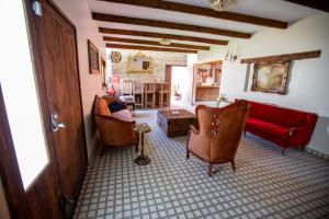 un soggiorno con sedie e un divano rosso di Hotel Estancia 1928 a Zacatlán