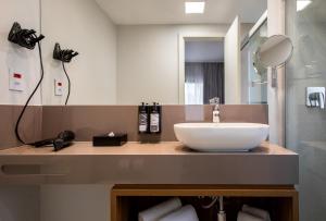 ein Badezimmer mit Waschbecken und Spiegel in der Unterkunft INNSiDE by Meliá São Paulo ITAIM in São Paulo + 37 Fotos