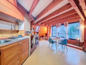 a kitchen with a table and chairs in a room at Gîte Bombom in Mittlach