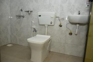 a bathroom with a toilet and a sink at Fortune Farms - Scenic resort with Raindance,Gazebo,Pool&Hill Views in Chinchavli +26 photos