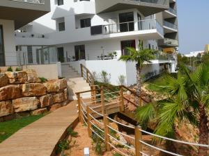 a house with a wooden walkway in front of it at Oasis by Templesuites - Praia da Rocha in Portimão
