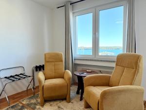 two chairs and a table in a room with a window at Studio Apartment Harbour Pula in Pula