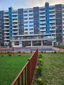a red fence in front of a large building at Syokimau Furnished Apartments in Nairobi