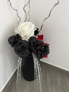 a black vase filled with black and white roses at holiday home Un posto solare in Naples