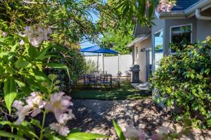 a patio with a table and a blue umbrella at Charm on Chestnut in Paso Robles