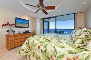 a bedroom with a bed and a ceiling fan at Top Floor Penthouse at The Mahana in Lahaina