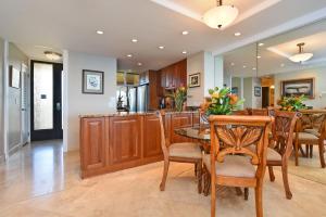 a kitchen and dining room with a table and chairs at Top Floor Penthouse at The Mahana in Lahaina