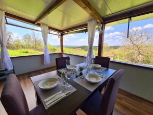 a dining room with a table and chairs and a large window at Vila Zornica in Kondolovo