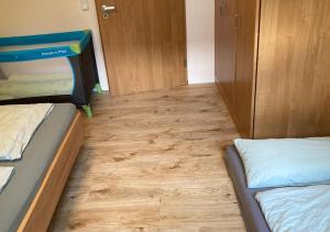 a room with two bunk beds and a wooden floor at Hecht Ferienvermietung - Fewo Turmfalke 2-Zimmer-Appartement mit Sauna und Schwimmbad in Sankt Englmar +51 photos