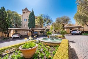 a courtyard with a fountain in front of a building at Cozy Corner in Sandton