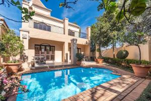 a swimming pool in front of a house at Cozy Corner in Sandton