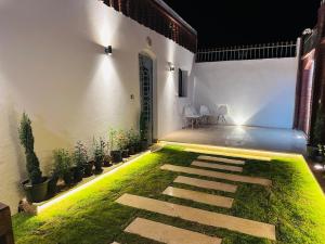 a courtyard with grass and a pathway with lights at Villa Farida Palace in Al Aqālitah