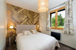 une chambre avec un lit blanc et une fenêtre dans l'établissement La clairière aux cerfs, à Ventron 43 autres photos