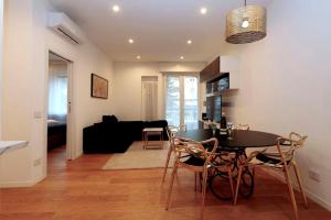 a dining room and living room with a table and chairs at Cozy Apartment between Sempione, City Life and MiCo ! in Milan