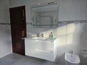 a bathroom with a sink and a mirror and a toilet at Casa Victoria - Laxe in Laxe