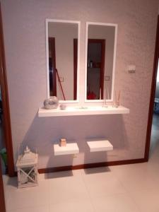 een badkamer met een wastafel en een spiegel bij Espiguiñas in Muros