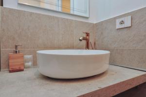 a large white tub sitting on a counter in a bathroom at Cozy Apartment between Sempione, City Life and MiCo ! in Milan +14 photos