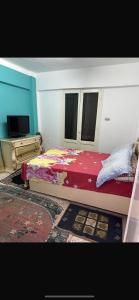 een slaapkamer met een bed en een tv erin bij Roma apartment in Dumyat al Jadidah