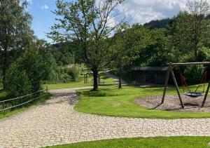 a playground in a park with a swing at Hecht Ferienvermietung - Fewo Turmfalke 2-Zimmer-Appartement mit Sauna und Schwimmbad in Sankt Englmar