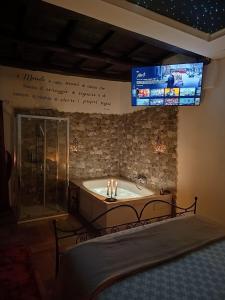 a bath tub with candles in a room with a tv at Le 10&10 SPA idromassaggio in camera Nepi VT in Nepi