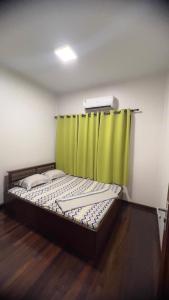 a bed in a room with a green curtain at Cozy two bedroom Apartment GiJa in Paramaribo +4 photos