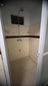 a bathroom with a shower with a tiled floor at Cozy two bedroom Apartment GiJa in Paramaribo