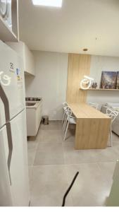 a kitchen with a refrigerator and a table in it at Lindo Apartamento no Centro de Porto de Galinhas in Porto De Galinhas