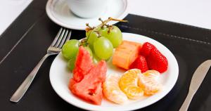 a white plate with fruit on a table at Castro's Park Hotel in Goiânia