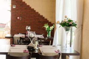 a dining room with a table with flowers on it at Hotel Podzamcze in Góra Kalwaria