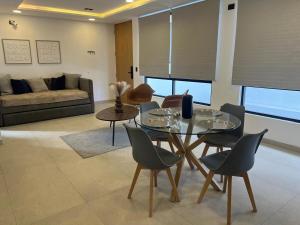 a living room with a glass table and chairs at Departamento al Norte de Aguascalientes in Aguascalientes +5 photos