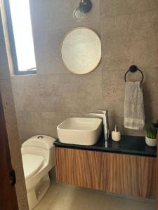 a bathroom with a sink and a toilet and a mirror at Departamento al Norte de Aguascalientes in Aguascalientes +5 photos