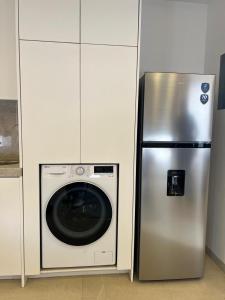 a refrigerator and a washing machine in a kitchen at Departamento al Norte de Aguascalientes in Aguascalientes