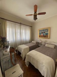 une chambre avec deux lits et un ventilateur de plafond dans l'établissement Depto 3 dormit Plaza Colon-Frente Al mar-SOLO para familias!, à Mar del Plata