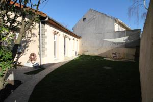einen Innenhof eines Gebäudes mit einem Rasenplatz in der Unterkunft La Maison de Louise in Aulnay-sous-Bois