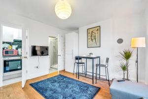a living room with a table and a kitchen at Park n Stay London, Free Parking, Kitchenette, Toiletries, Only 30 Min to Wembley and Central London in Colindale