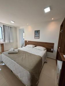 a bedroom with a large bed with two towels on it at Hotel Gogó da Ema in Maceió