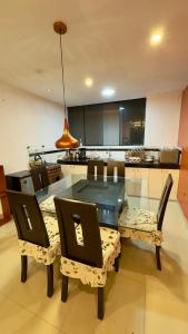 a dining room with a glass table and chairs at Castellares la Puebla Hostelería Departamento in Ayacucho